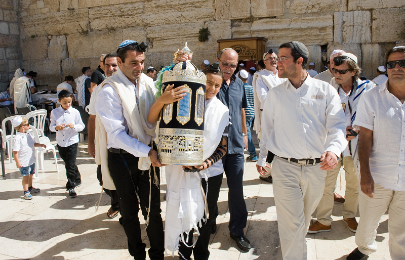 Boy carries the Torah scrolls during a Bar Mitzvah at the Western Wall