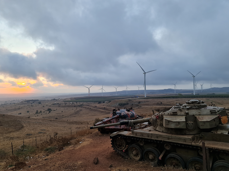 Two tanks and in the background, the wind turbines of the Golan